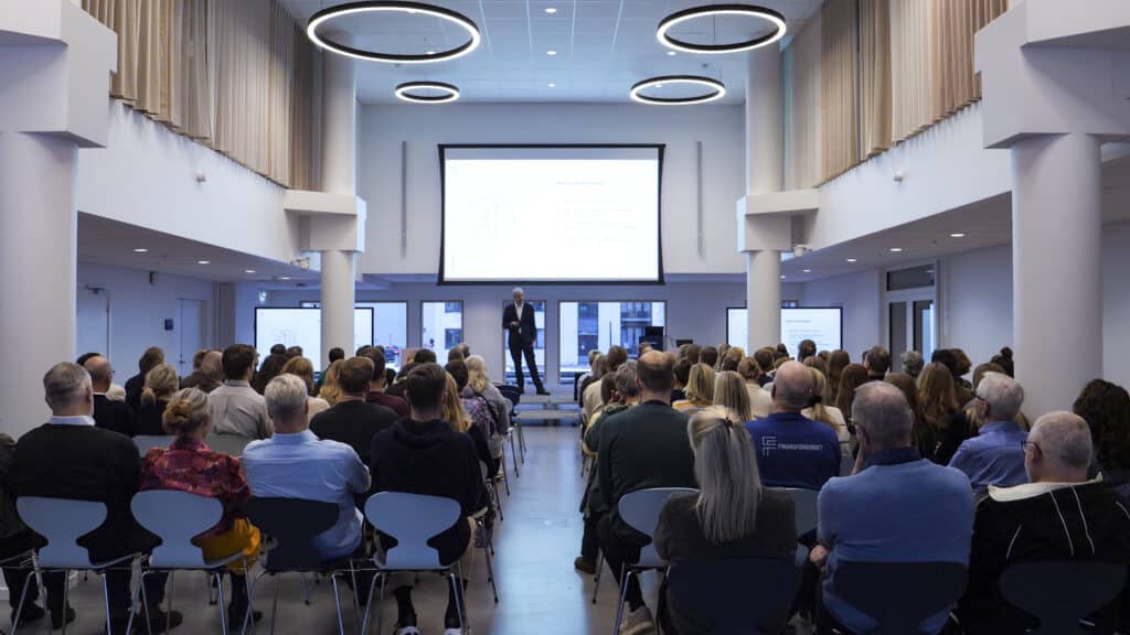 Finansforbundets direktør Jonas Svava Iversen på scenen i Finansforbundets auditorie med AV udstyr designet af EnCollab