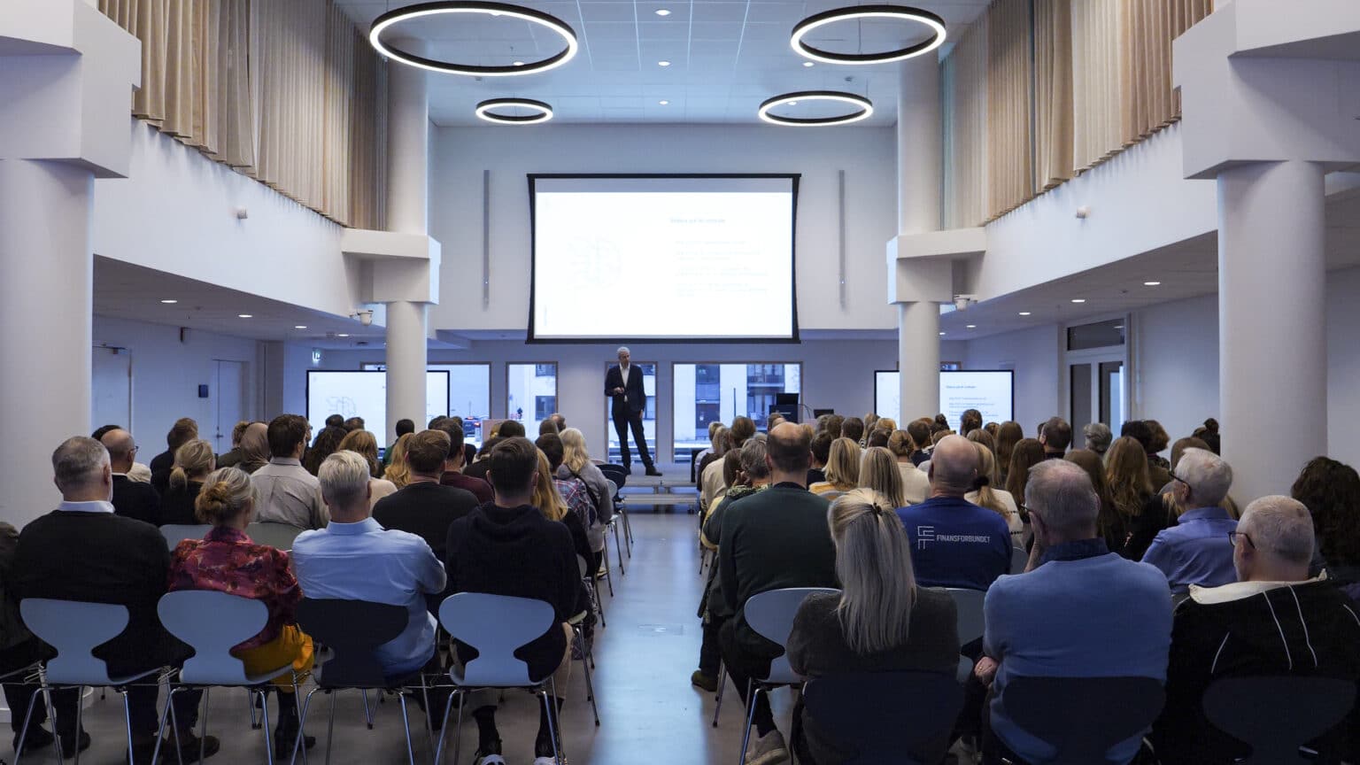Finansforbundets direktør Jonas Svava Iversen på scenen i Finansforbundets auditorie med AV udstyr designet af EnCollab